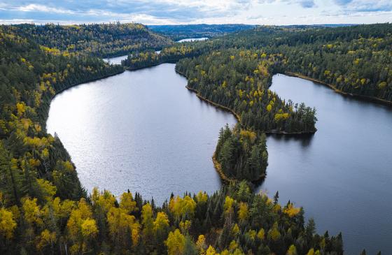 An aerial view of a few Boundary Waters lakes surrounded by autumn woods.