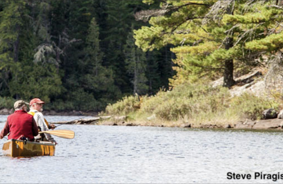 Two anglers sit in a canoe in the Boundary Waters