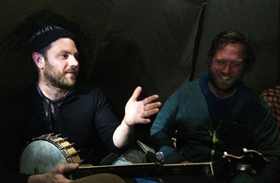 Ben Weaver holding banjo sitting in tent with Dave Freeman