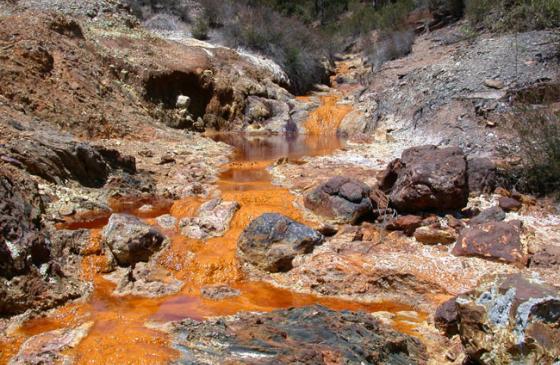 Orange, polluted water flowing down a waterfall