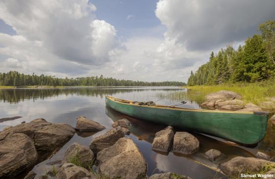 A picture of a canoe resting on the shores of a Boundary Waters lake. (Photo Credit: Samuel Wagner)
