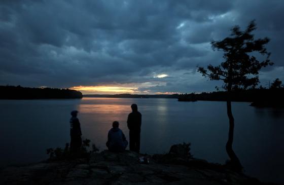 Urban Boatbuilders Apprenticeship participants at their campsite on a cloudy evening in the BWCA