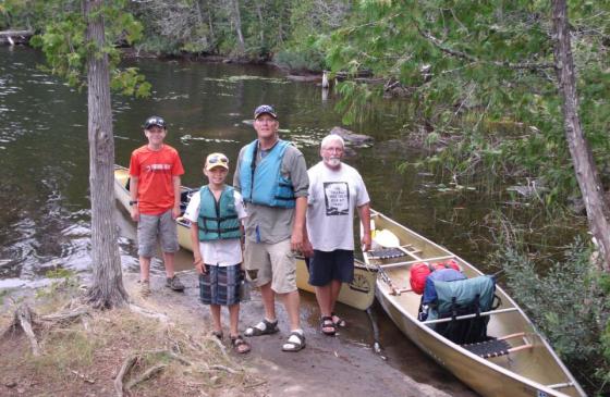 Group of people standing next to a canoe