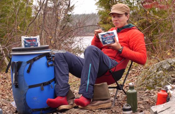 Amy Freeman sitting on a camp chair eating a trail meal