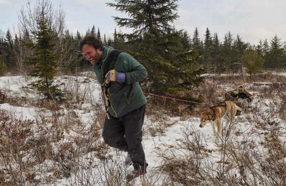 Photo of Dave Freeman smiling, running through the snowy wilderness