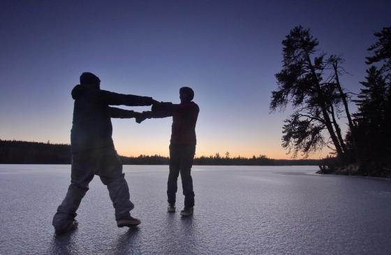 Photo of Amy and Dave Freeman dancing on a frozen lake together at sunset 