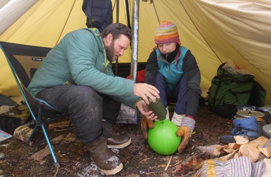 Photo of Amy and Dave Freeman making luminaries under a tarp