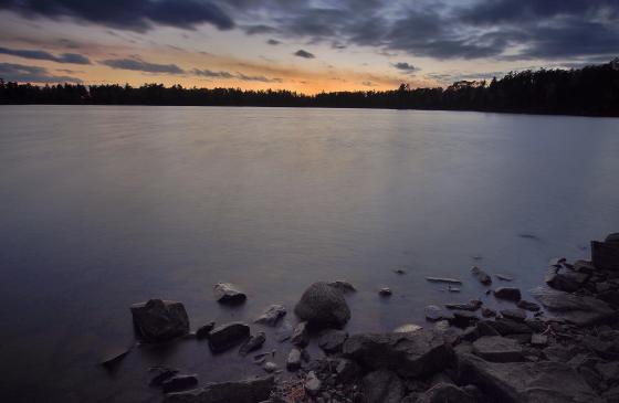 Photo of dark sky and dark water as the sun sets over the Boundary Waters