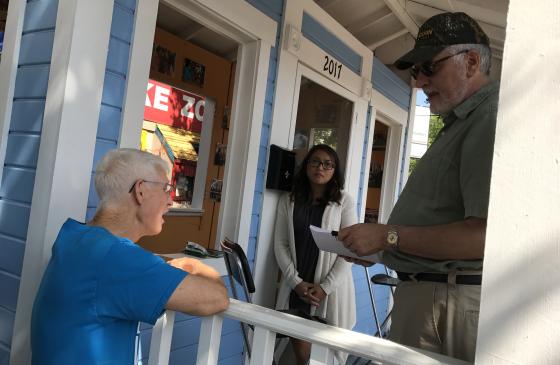 Photo of volunteer Tom Bose leaning on railing and delivering petitions at Minnesota State Fair 2017