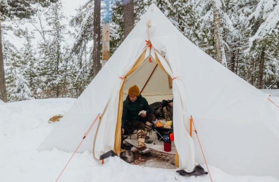 Person inside a white winter camping tent. Photo: Nate Ptacek