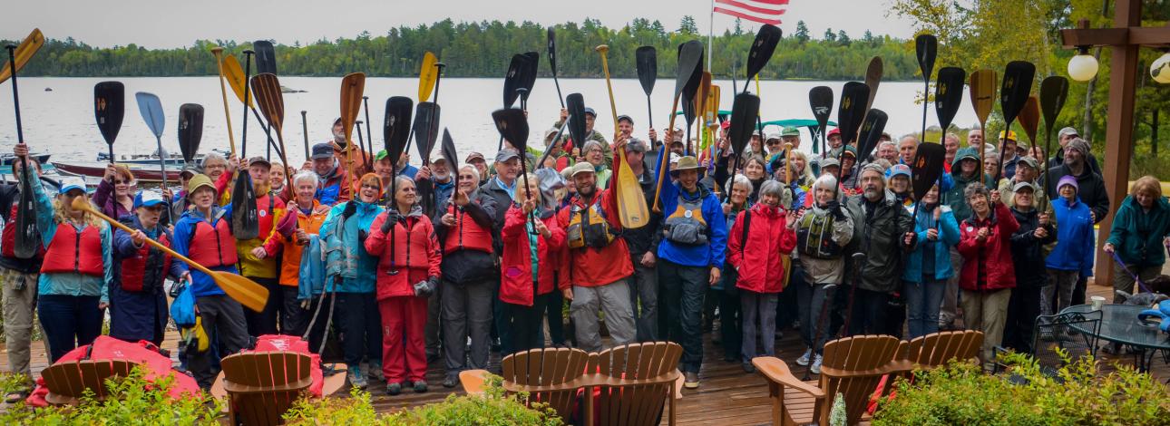 Supporters raise their paddles at the launch event for Amy and Dave Freeman's Year in the Wilderness.