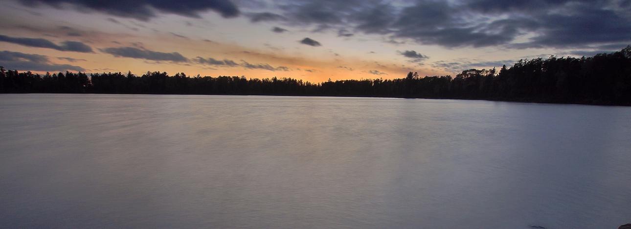 Sunset on rocky shore of Boundary Waters. 